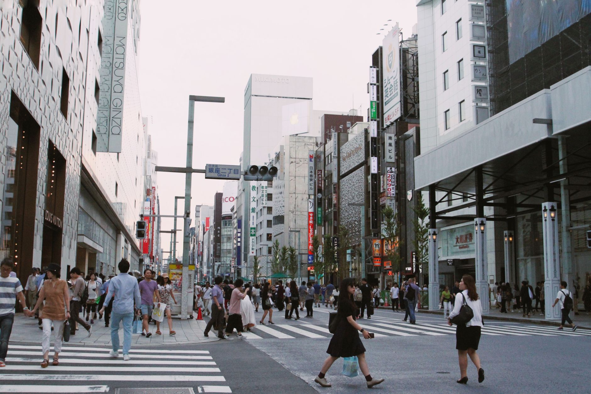 Pedestrians crossing the famous Shibuya intersection in Tokyo with orderly lanes and no collisions during rush hour.