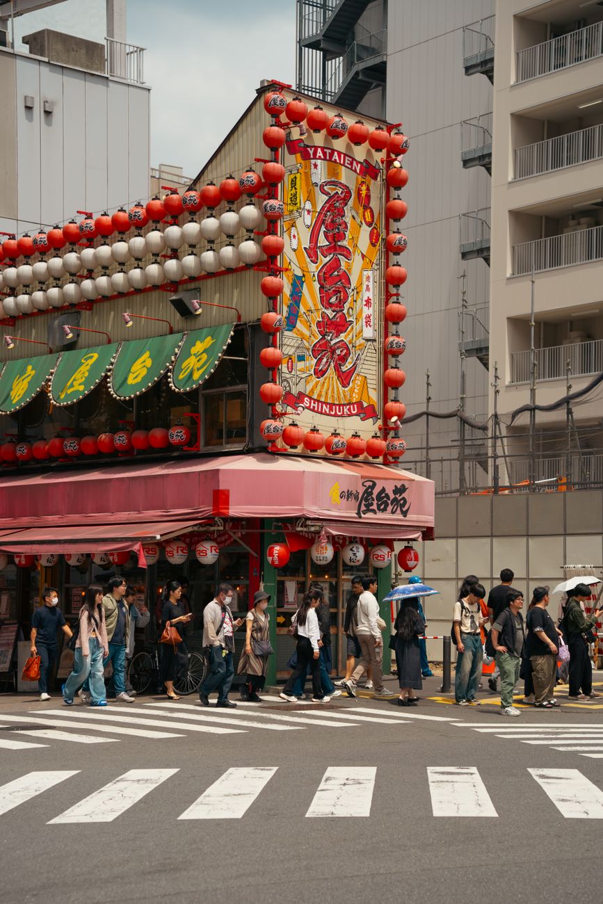 Pedestrians crossing the famous Shibuya intersection in Tokyo with orderly lanes and no collisions during rush hour.