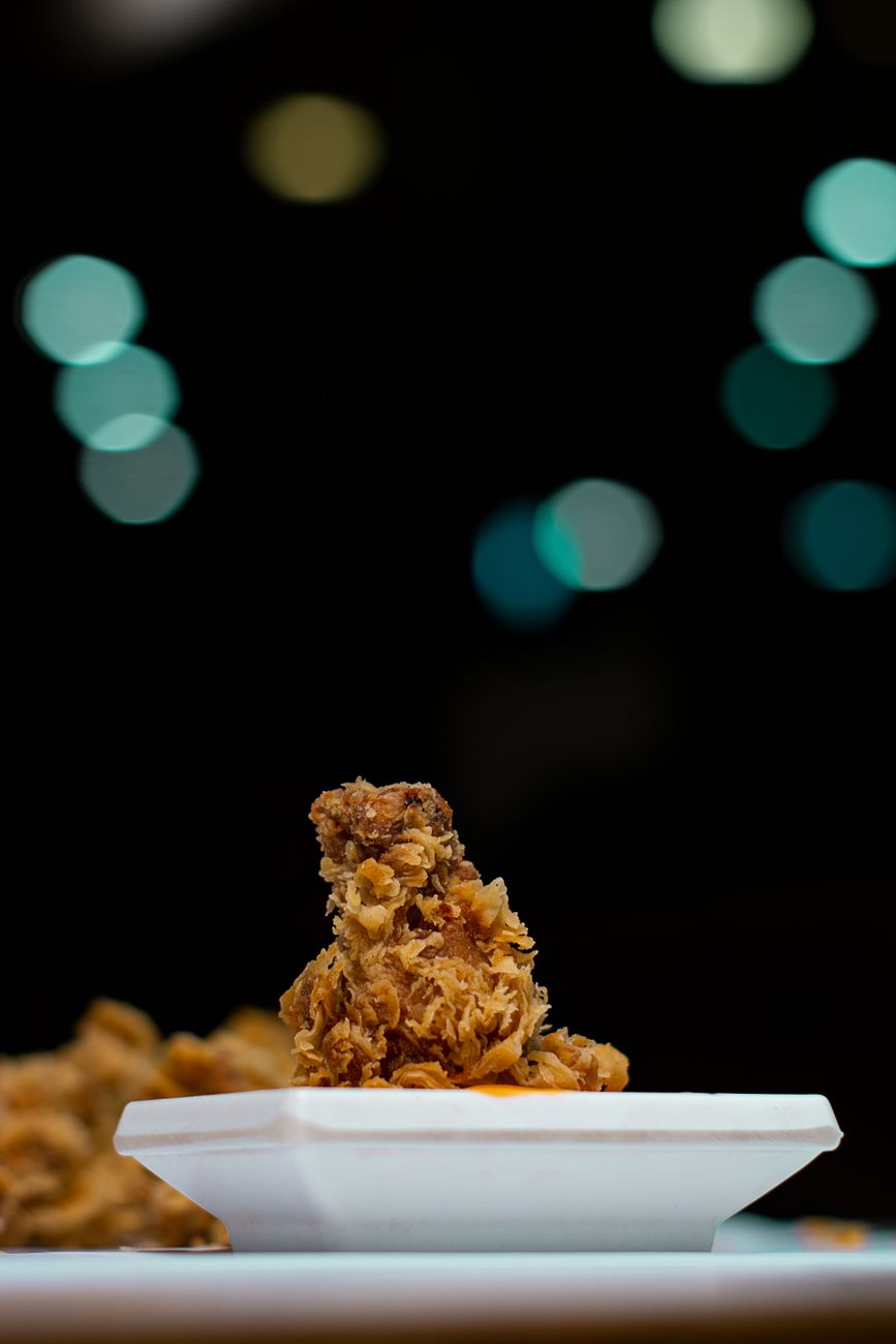 A red and white KFC bucket filled with fried chicken sits on a Japanese family's Christmas table with festive decorations.