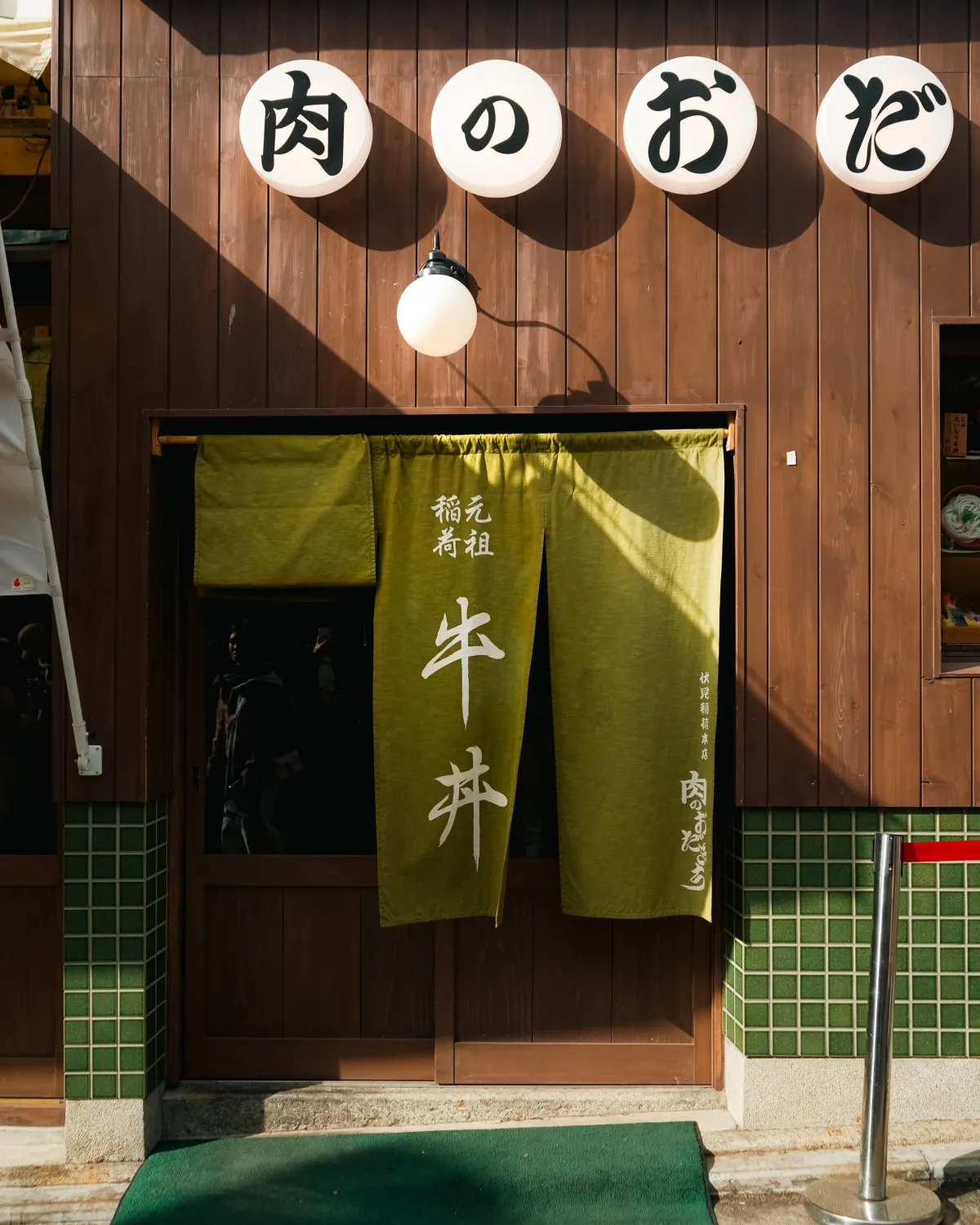 Traditional Japanese noren curtain hanging at a shop entrance with indigo fabric and white kanji characters in Kyoto.