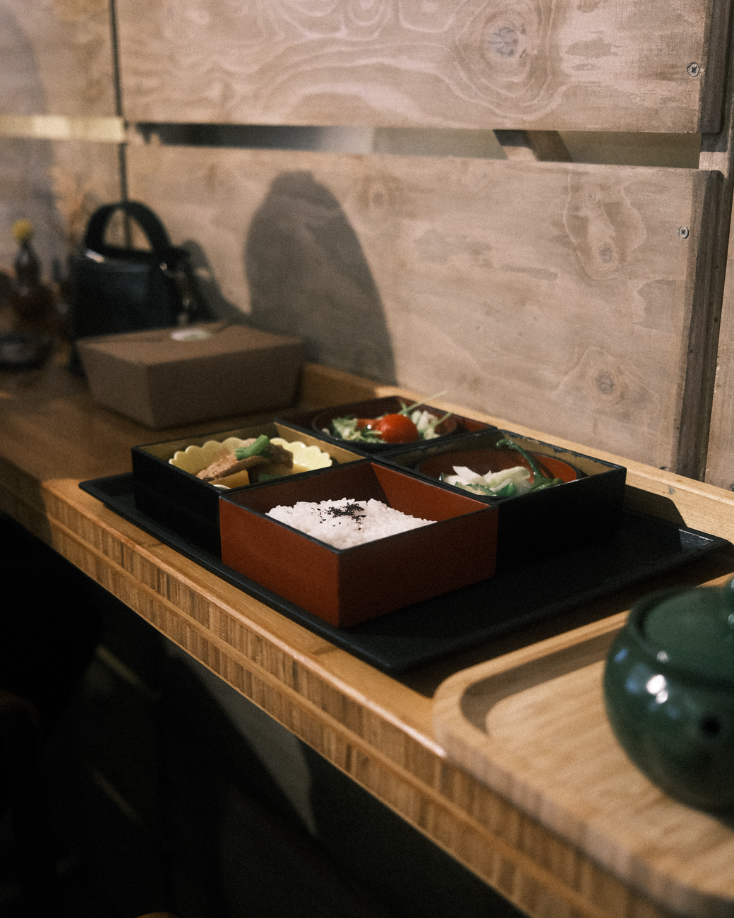 Colorful displays of Japanese sweets, bento boxes, and fresh produce arranged in pristine glass cases at a bustling department store basement.