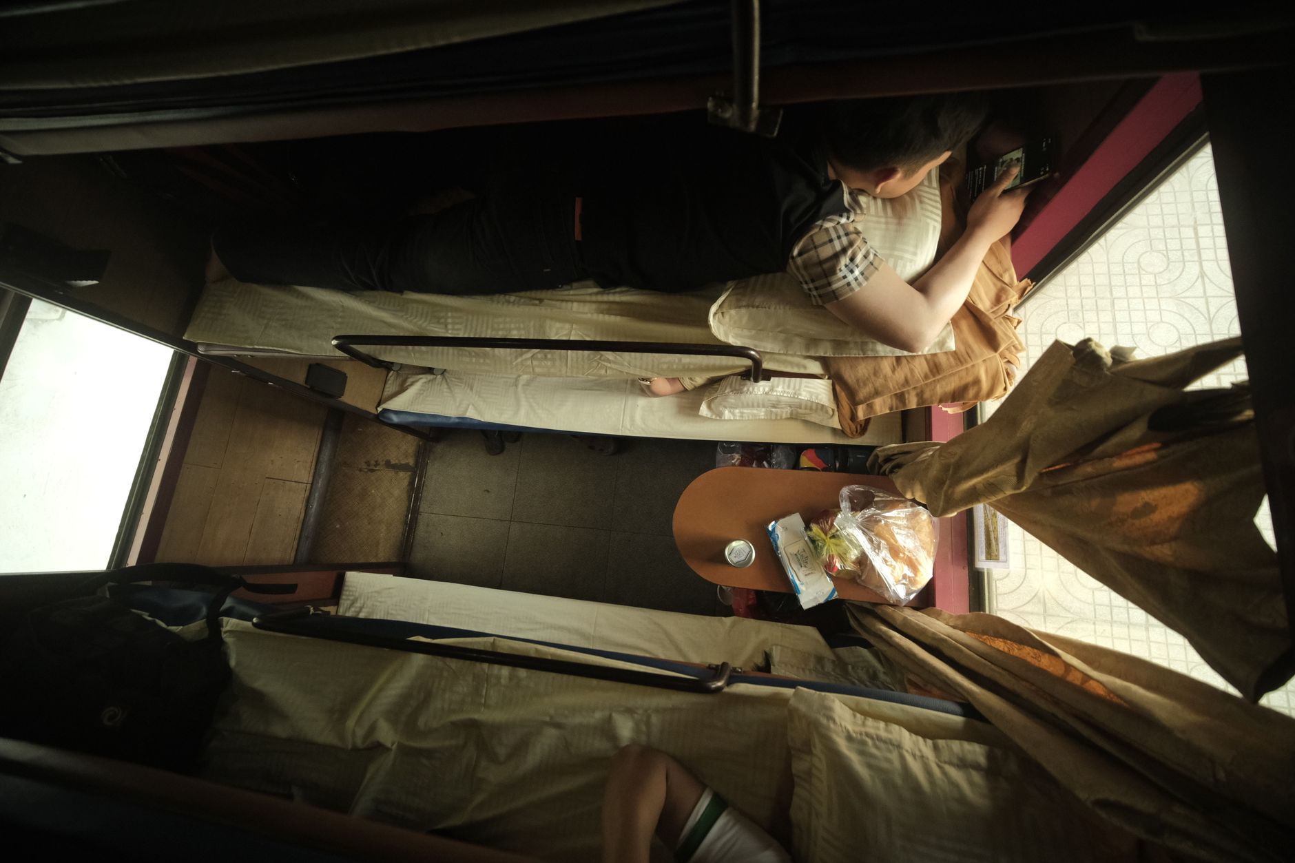 Japanese businessman in suit sleeping upright on train seat during morning commute, head tilted back with briefcase on lap.