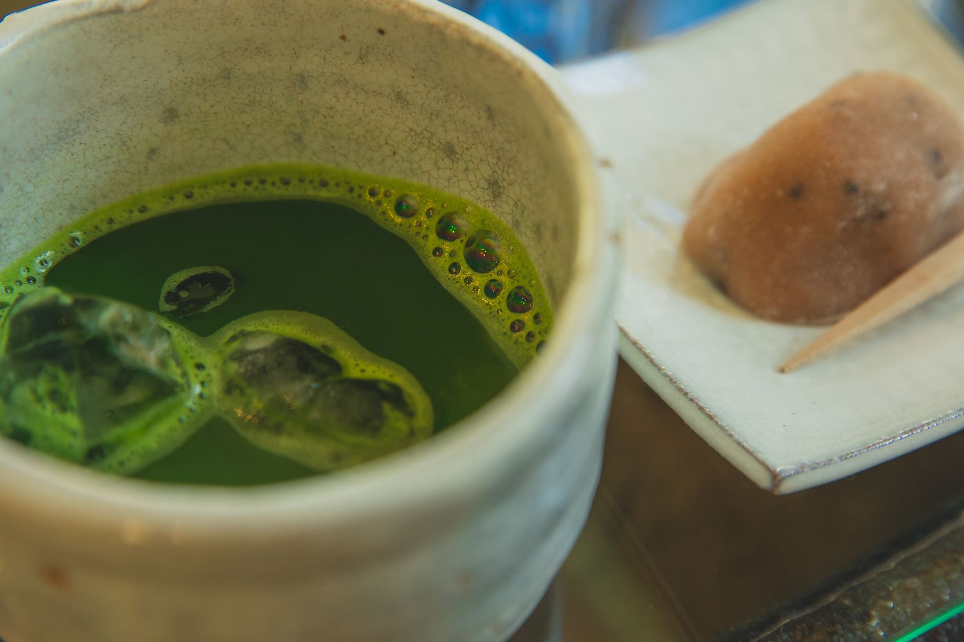 Verdant tea fields cascade down hillsides in Uji, with traditional covered cultivation structures protecting premium matcha plants from direct sunlight.