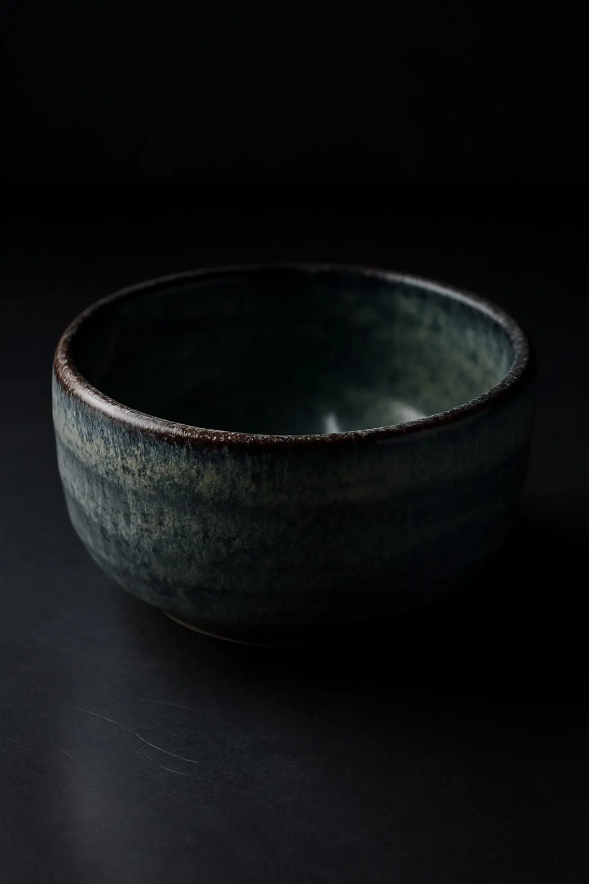 Traditional Mino ware ceramic bowls displaying various glazing techniques including Shino, Oribe, and Seto-guro styles arranged on wooden surface.