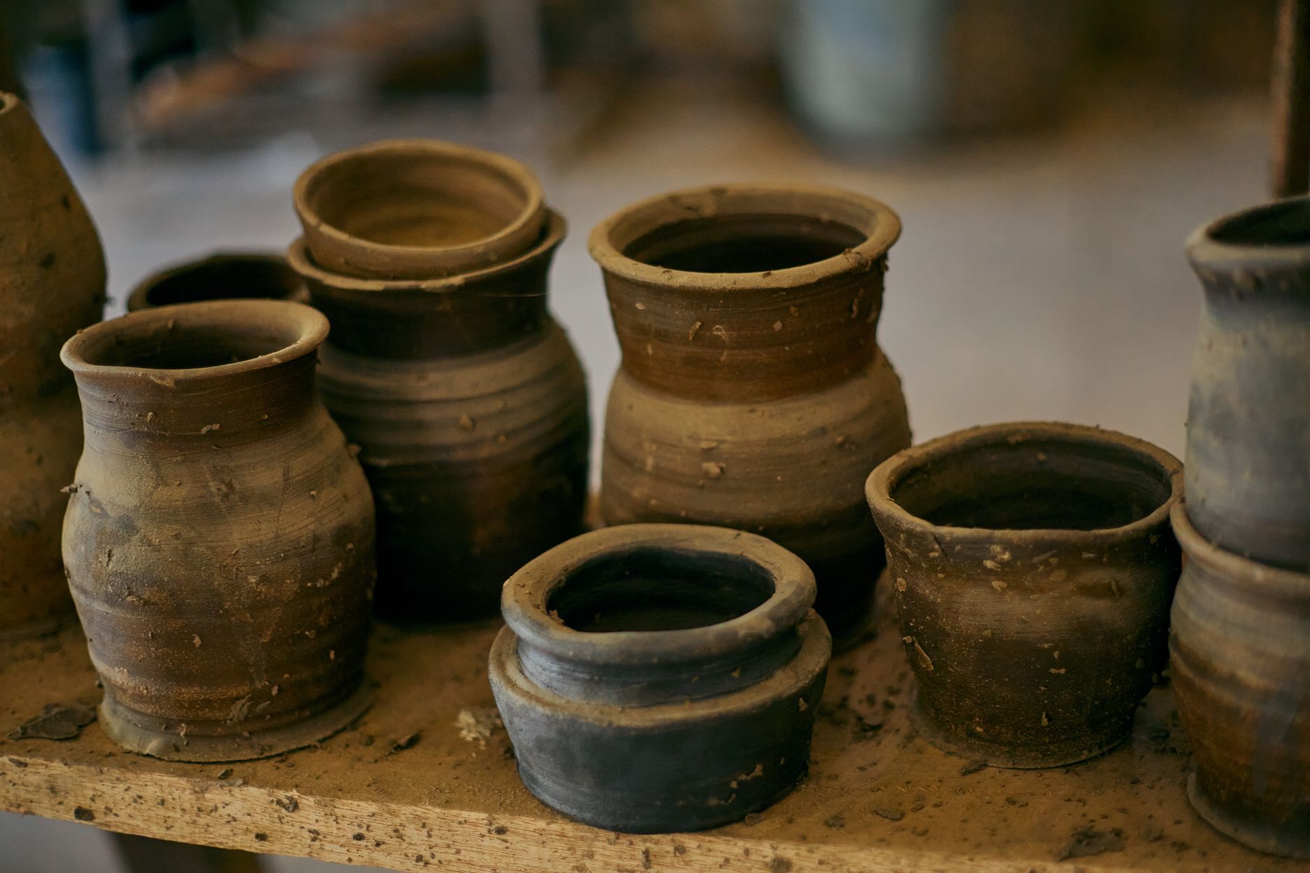 Traditional Bizen ware tea bowl showing natural ash glaze patterns and reddish-brown clay from wood-fired kiln firing.