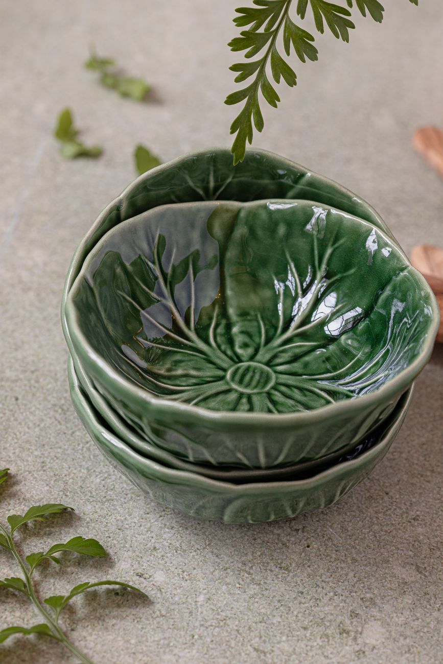 Close-up of traditional Japanese Oribe ware tea bowl featuring distinctive copper-green glaze with bold geometric black brushwork patterns.
