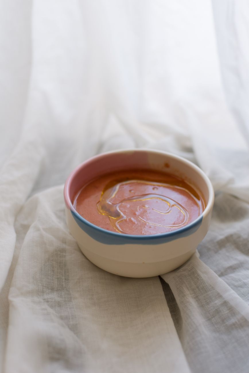 Close-up of Shino-glazed ceramic bowl showing characteristic warm white surface with subtle orange fire marks and textured glaze pooling.
