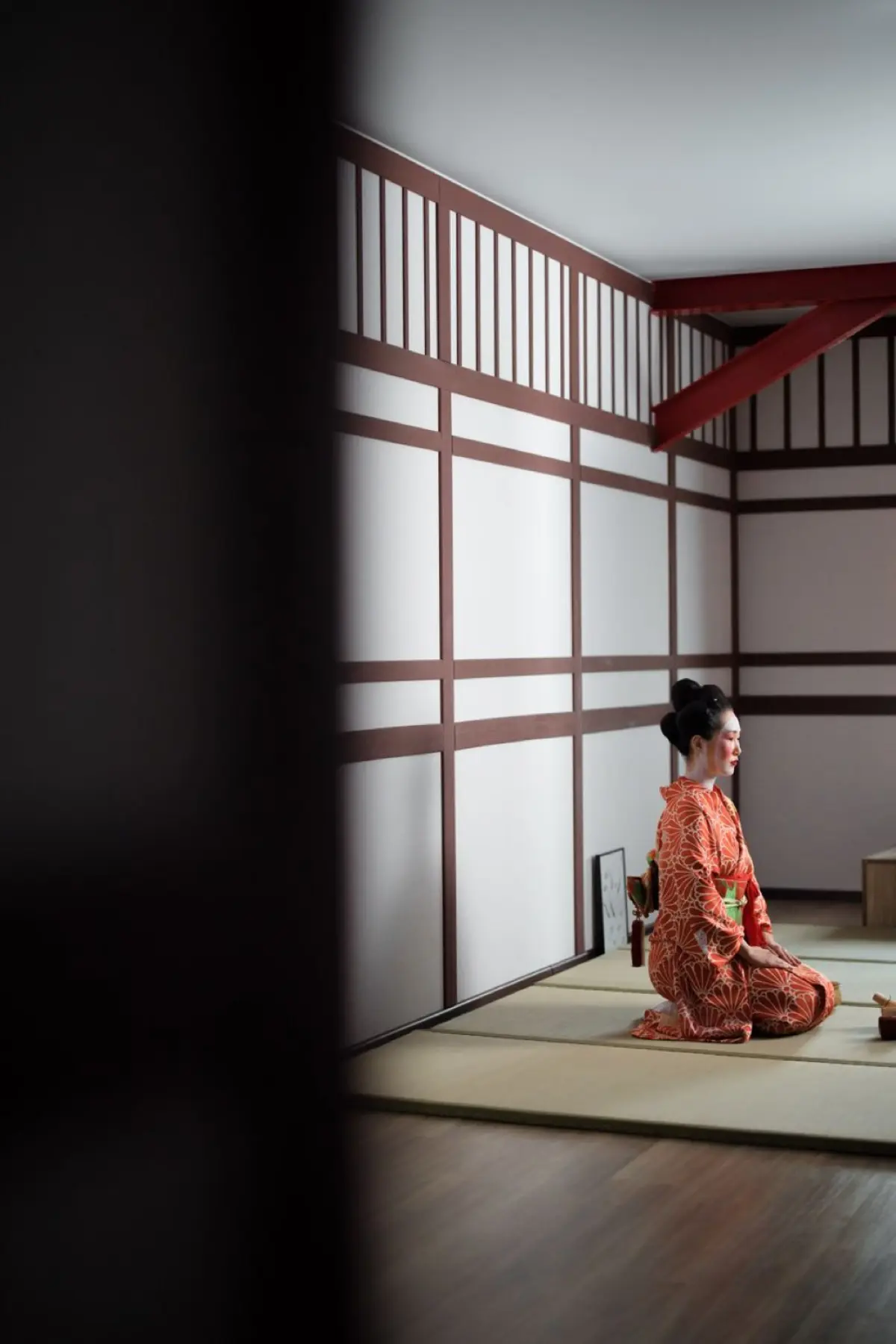 A host in kimono preparing matcha with a bamboo whisk in a quiet tatami tea room