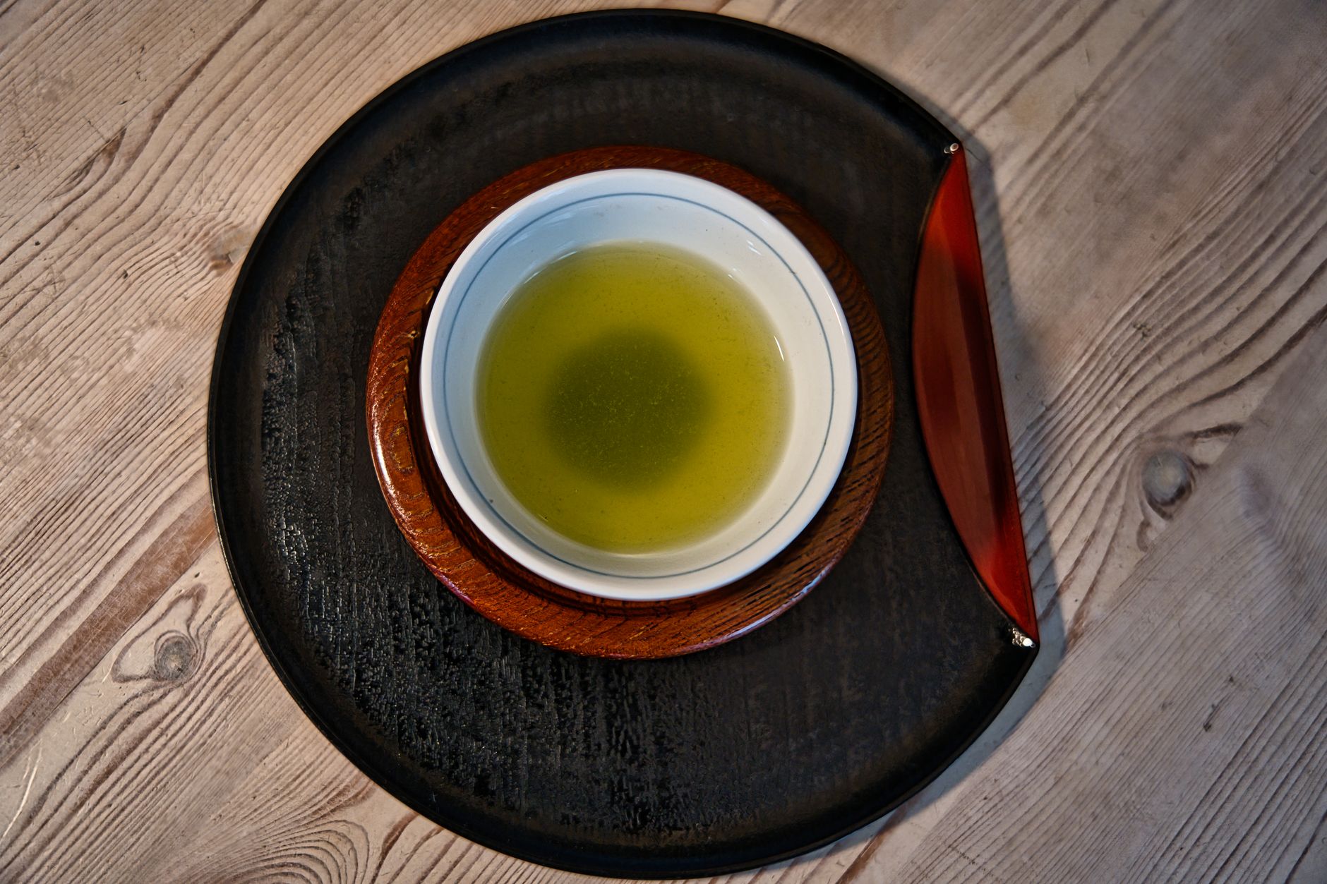 Traditional Japanese tea ceremony host whisking matcha in ceramic bowl during formal chado practice in tatami room.