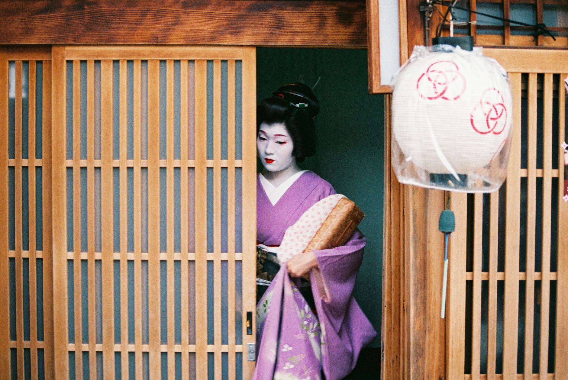 Traditional Japanese tea ceremony host preparing matcha in a minimalist tea room with tatami mats and simple bamboo utensils.