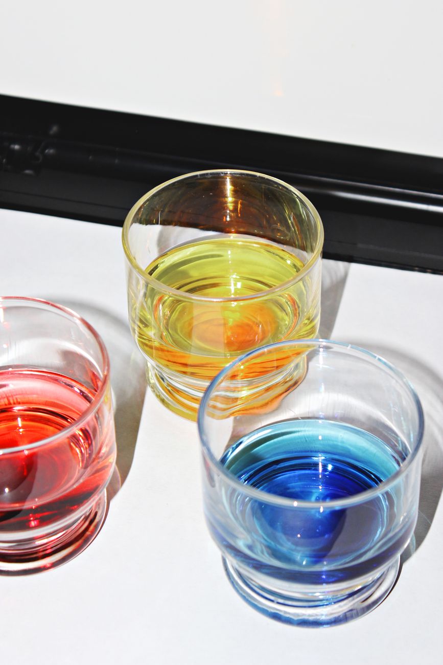 Colorful Tsugaru Bidoro glass vessels in layered blues, greens, and amber displaying traditional Japanese marbled patterns and organic forms.