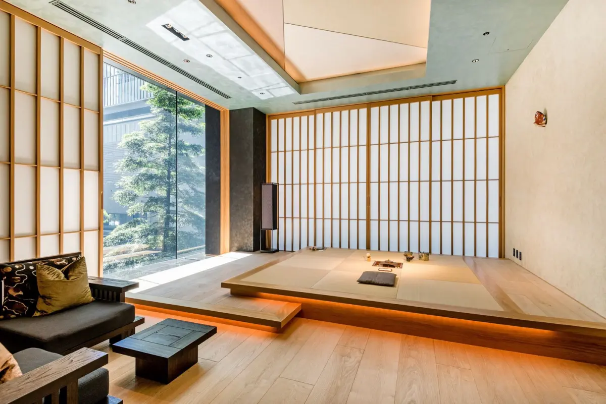 Traditional Japanese tokonoma alcove in a tea room featuring a hanging scroll, ikebana flower arrangement, and tatami mat flooring.
