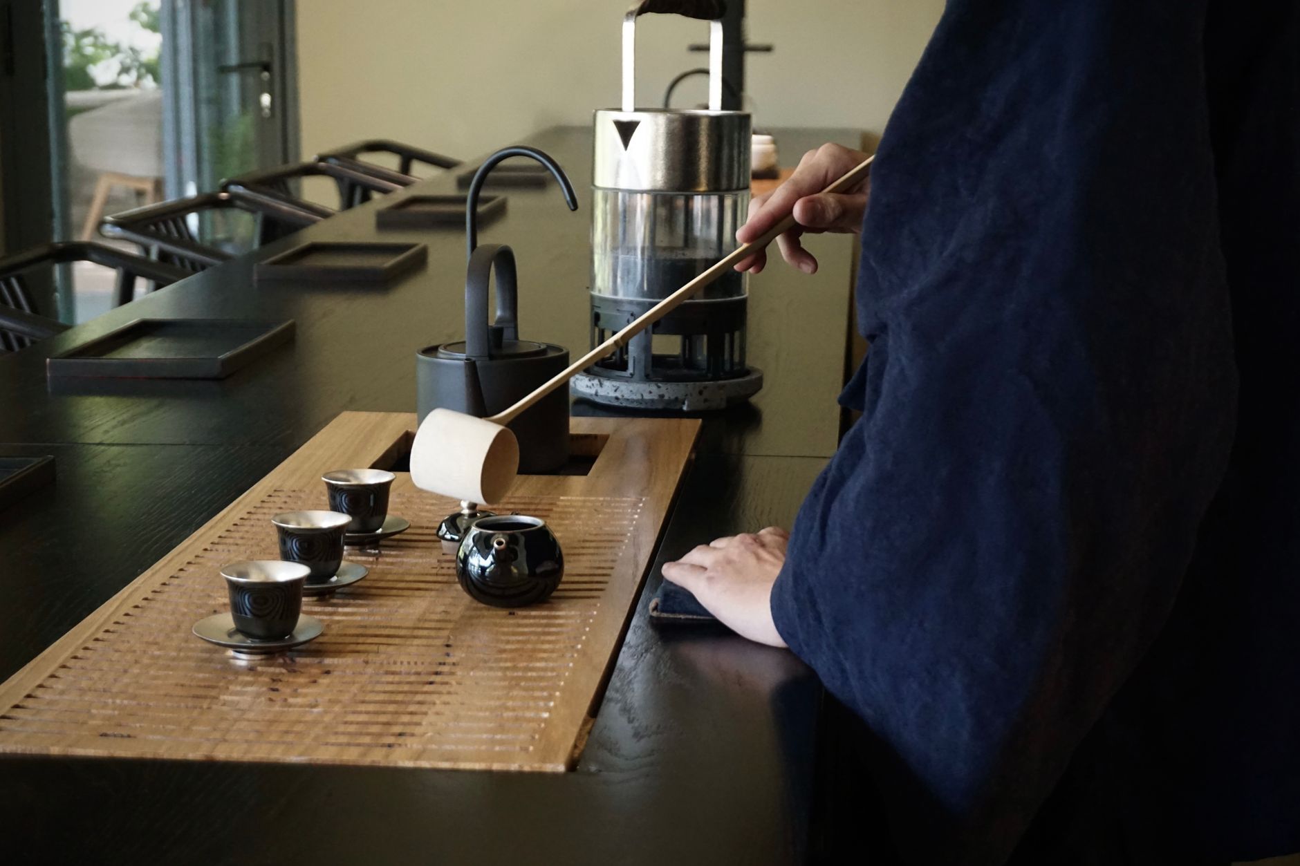 Zen monks preparing powdered matcha in a simple tatami room with shoji screens during the fifteenth century.