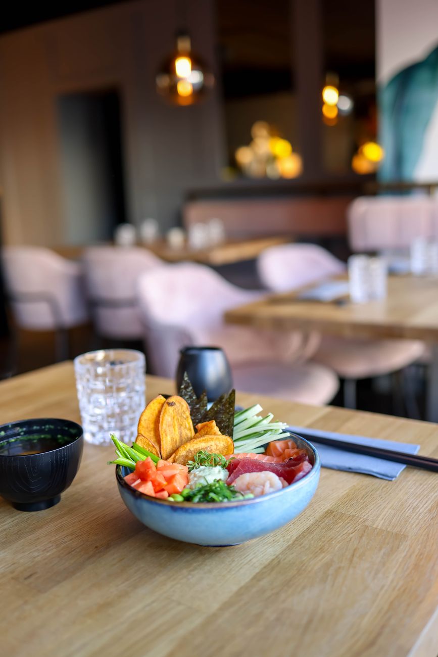 Traditional Japanese meal setting showing rice bowl on the left, miso soup on the right, with chopsticks and side dishes arranged properly.