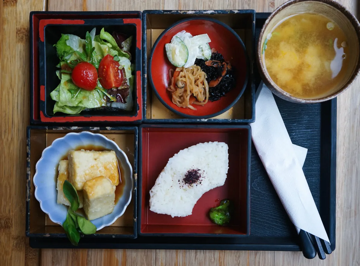 Traditional Japanese bento box displaying balanced compartments filled with rice, grilled fish, pickled vegetables, and colorful seasonal side dishes.
