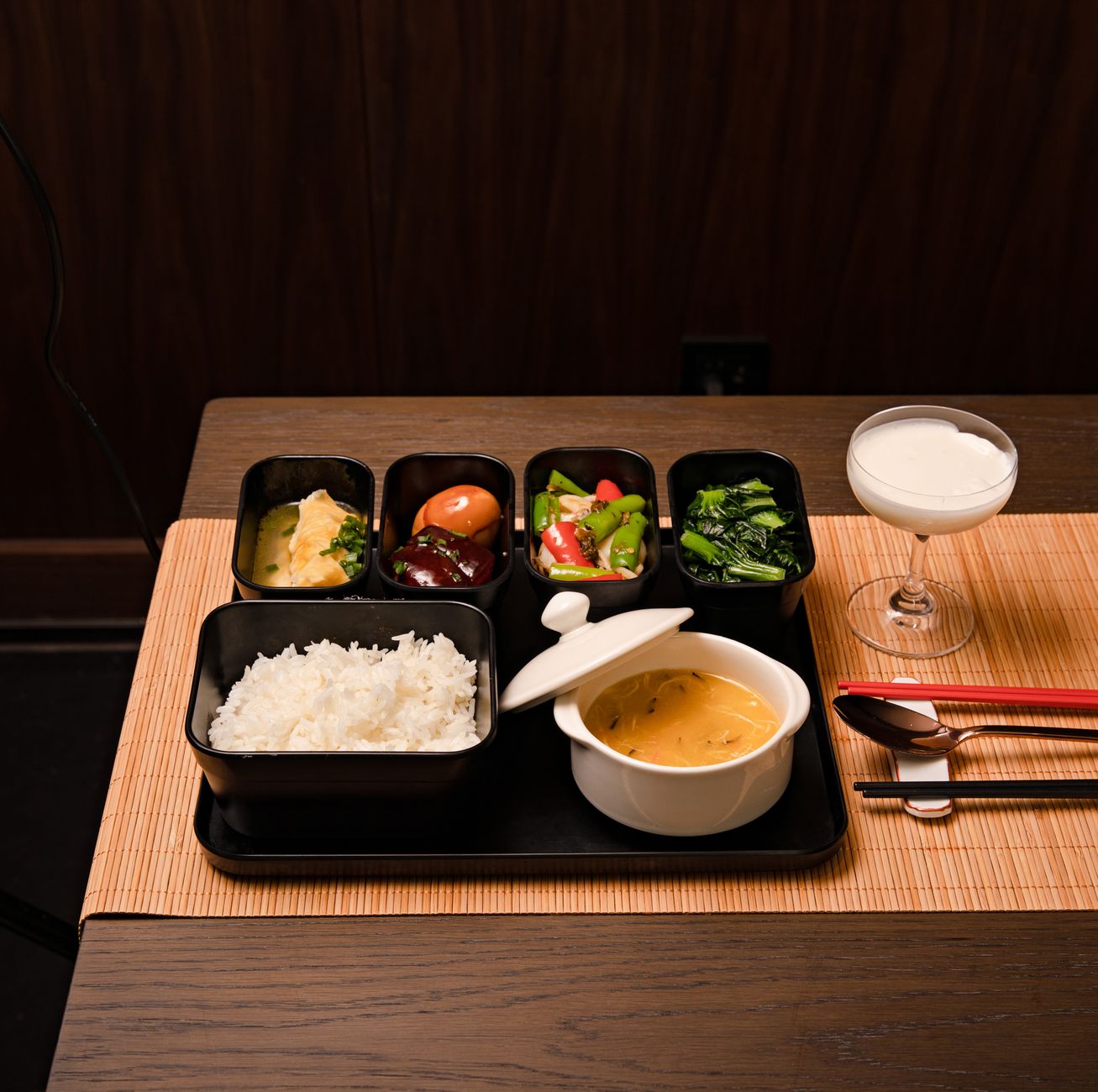 Traditional Japanese meal arrangement showing one soup, three dishes, rice and pickles on lacquered trays in formal samurai dining style.