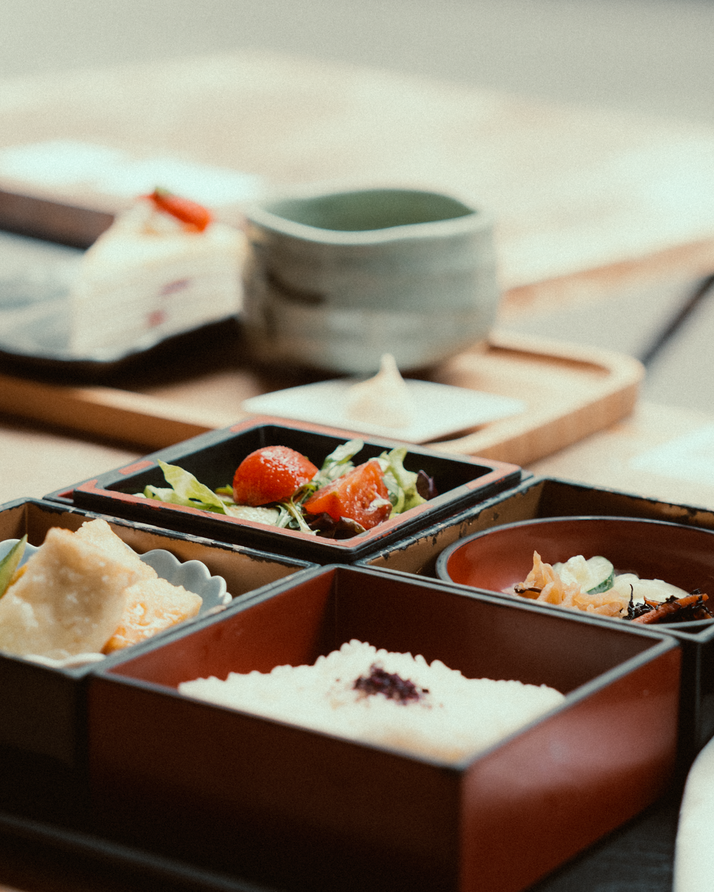 Japanese autumn tableware featuring red and yellow maple leaf garnishes arranged on ceramic plates with seasonal food presentation.