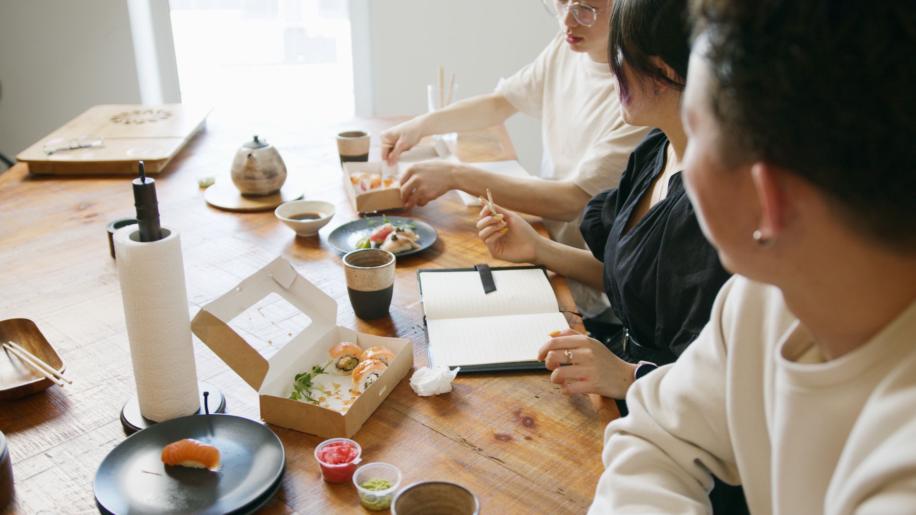 White and blue Arita porcelain bowls and plates arranged on a traditional Japanese dining table with chopsticks and tea cups.