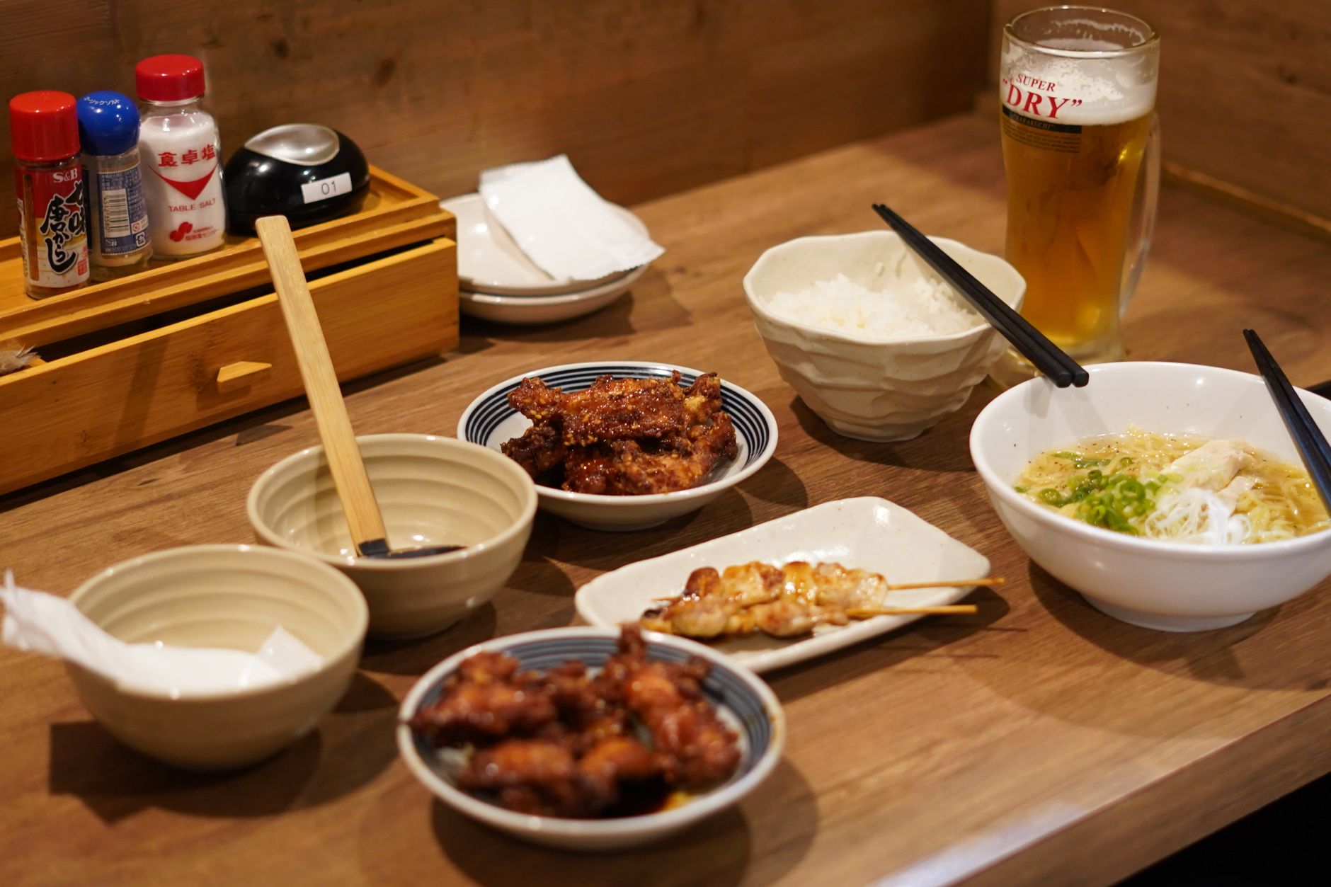 Traditional Japanese lacquer bowl and ceramic bowl side by side on wooden table displaying contrasting textures and finishes for soup service.