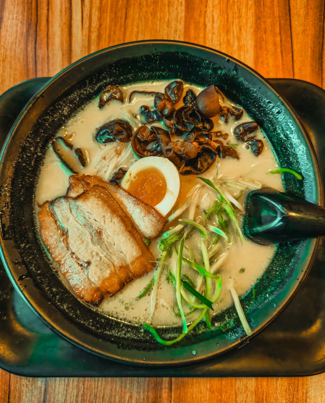 Traditional Japanese lacquer bowl and ceramic bowl side by side on wooden table displaying contrasting textures and finishes for soup service.