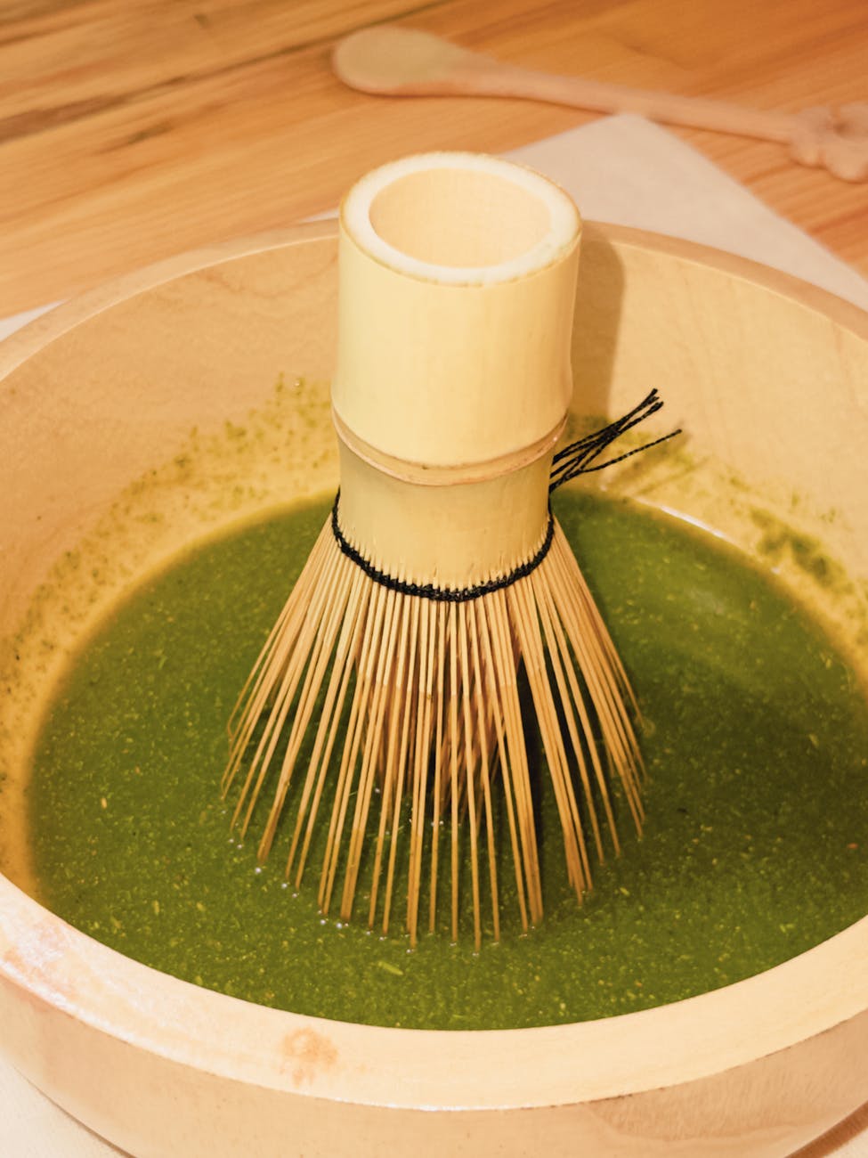 Two bowls of vibrant green matcha powder side by side showing different textures and color grades on bamboo mat.