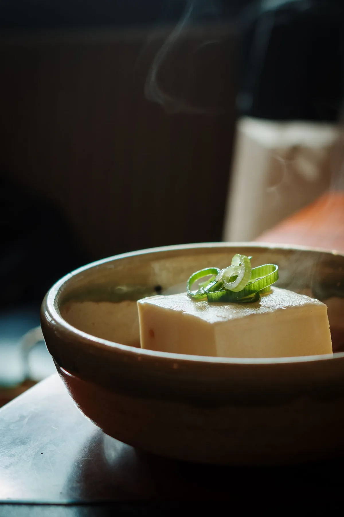 Lacquered tray displaying five small ceramic bowls containing seasonal vegetables, tofu, pickles, and miso soup in traditional shojin ryori arrangement.