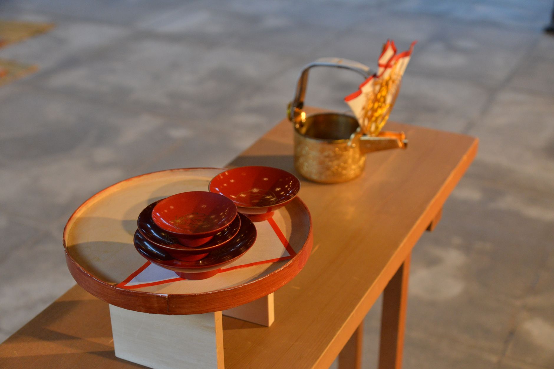 Guest's hands gently rotating a ceramic tea bowl clockwise to admire its decorative front before drinking matcha.