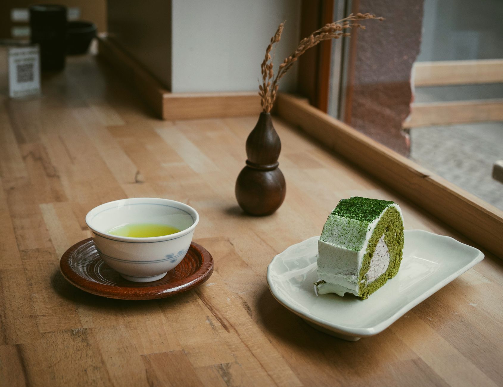 Traditional granite millstones grinding green matcha tea leaves into fine powder in a Japanese tea production facility.