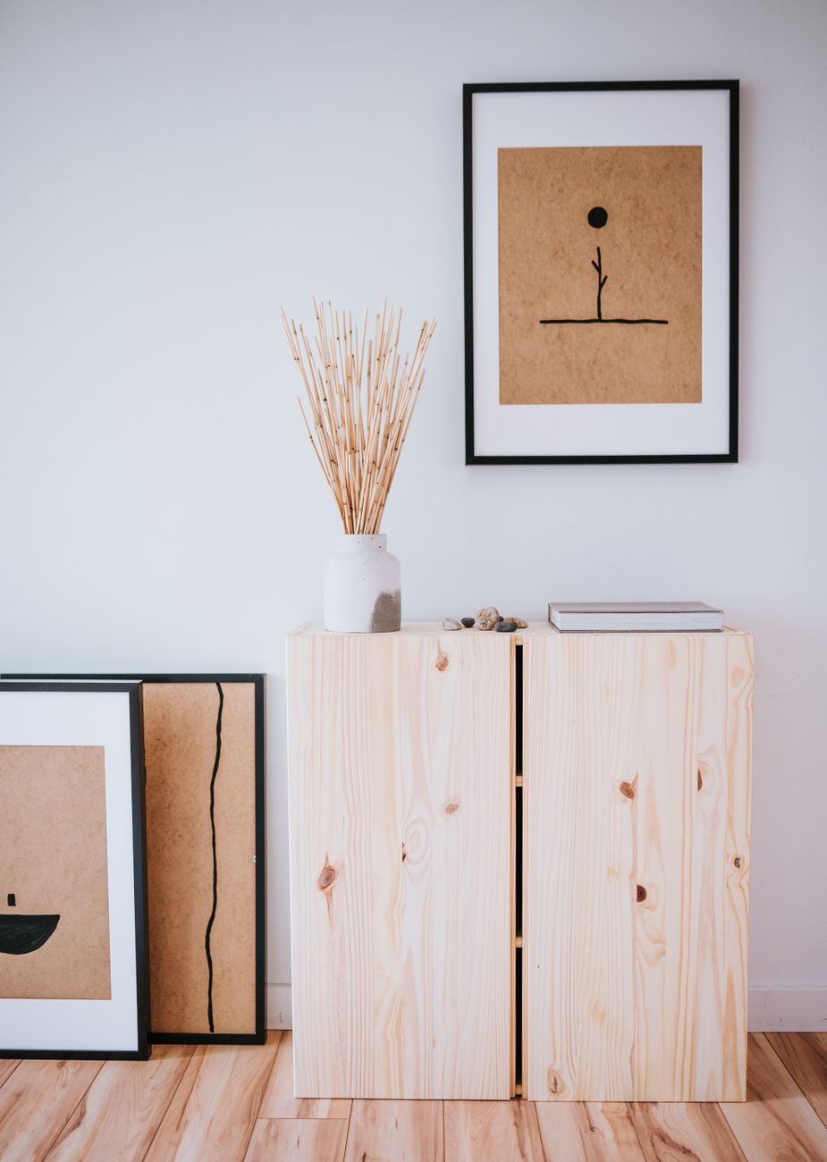 Minimalist Japanese-Scandinavian interior with pale wood furniture, white walls, and natural light creating shadows