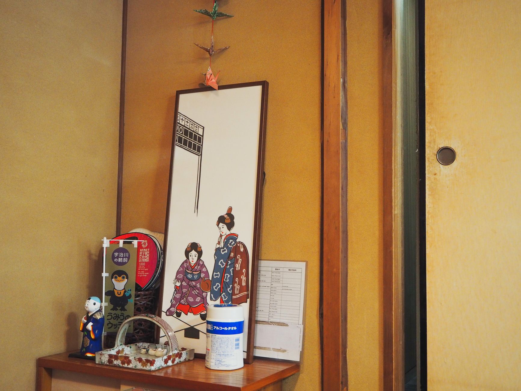 Traditional Japanese tokonoma alcove with hanging scroll, ikebana flower arrangement, and tatami mat flooring