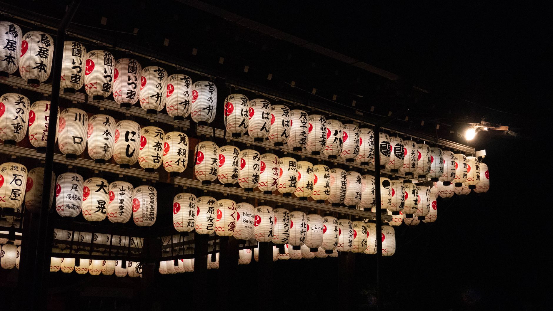 Traditional Japanese andon lamp with translucent washi paper glowing softly in a minimalist room with wooden frame