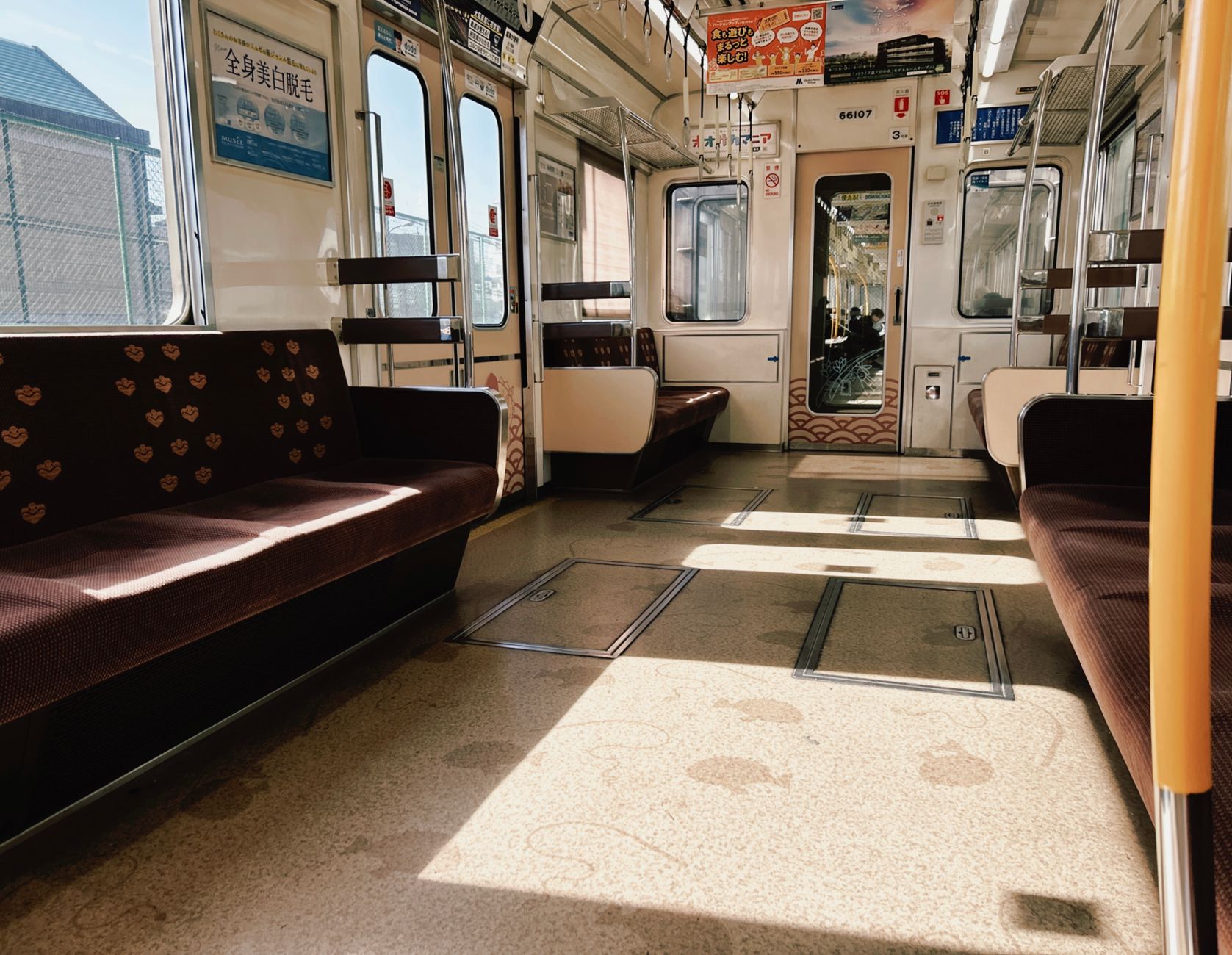 Priority seating area on a Japanese train with distinct colored seats and pictogram signage above the windows