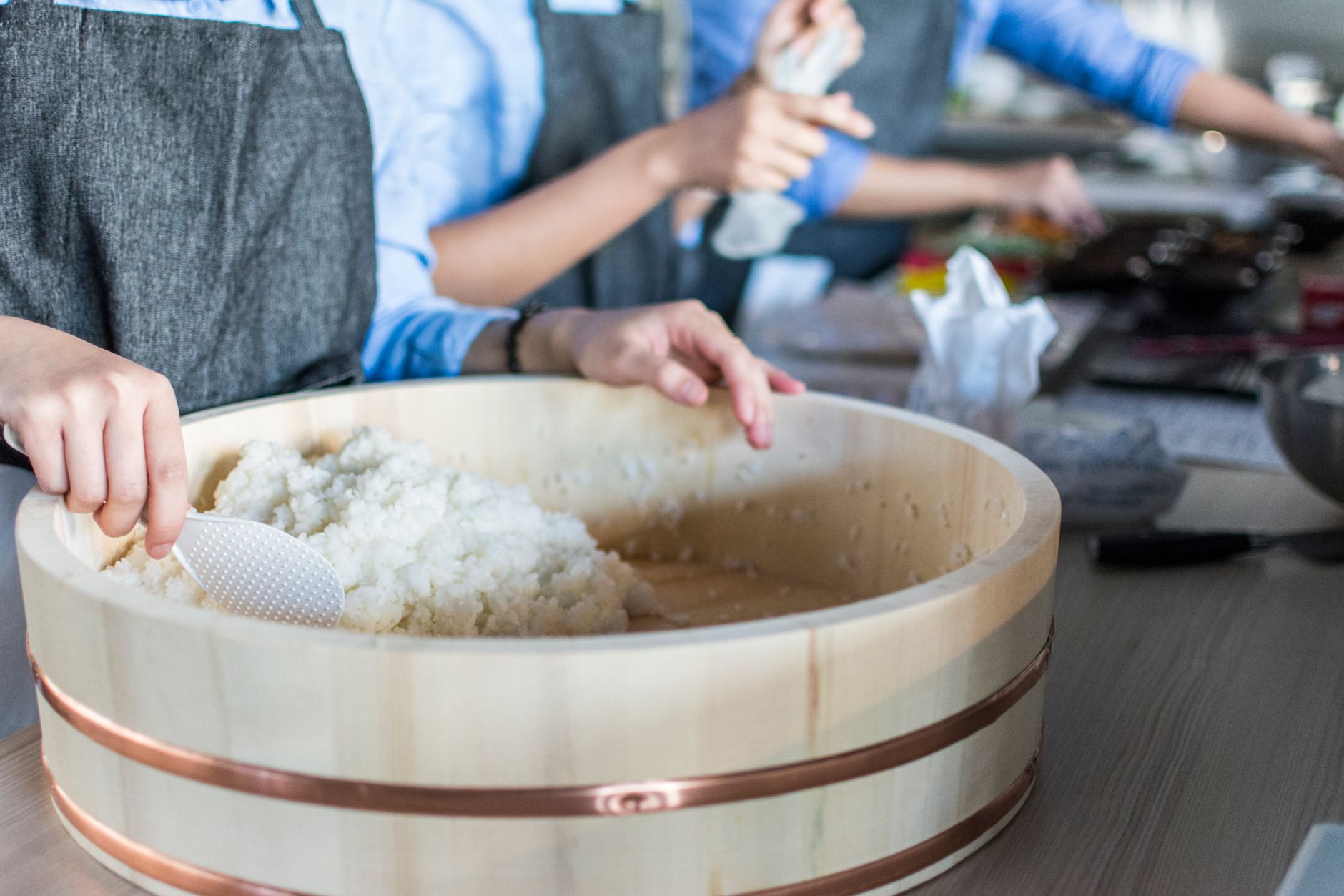 Steaming white rice in a traditional Japanese wooden bowl, grains glistening with a subtle sheen under soft natural light