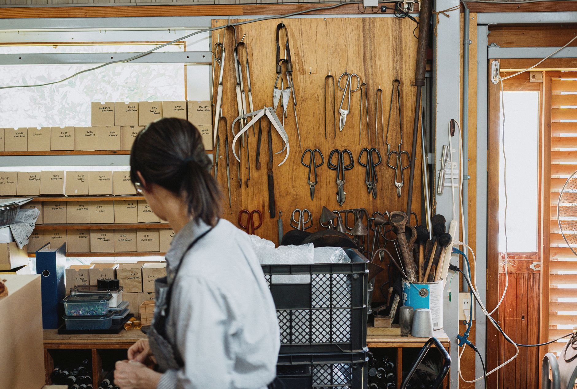 Weathered wooden mold for shaping Japanese teacups resting on a craftsman's workbench in a ceramic studio